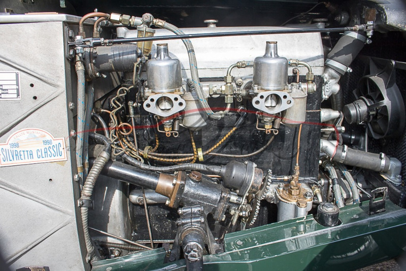 Ein detailliertes Bild eines alten Automotors mit sichtbaren Ventilen, Rohren und einem "Silvretta Classic" Schild.